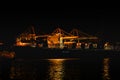 Night view of trieste harbor from the mediterranean sea. disembarkation of a container ship with yellow cranes Royalty Free Stock Photo