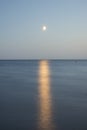 At night a white moon over the sea with a reflection and a path Royalty Free Stock Photo