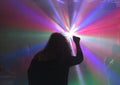 Nightclub silhouette of person with hand up and dancing