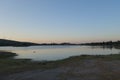 Nightfall on lake with wind power tower Royalty Free Stock Photo