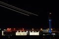 Nightime view of the Atlanta international airport with air traffic control and streaks of planes taking off over bright hangars Royalty Free Stock Photo