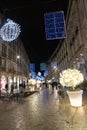 Nightime view of many people visiting the famous Christmas market in Strasbourg with colorful and bright light displays