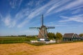 The Nightingale windmill in the middle of farm lands in Northern Netherlands with blue sky background Royalty Free Stock Photo