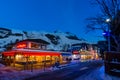 Nightlife in alpine village with traditional wooden houses, shops and restaurants Royalty Free Stock Photo