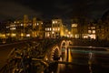 Nightscape with light trails of cars and boats crossing above the canals of Amsterdam