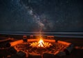 A nighttime beach scene features a brightly burning campfire Royalty Free Stock Photo