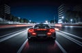 Nighttime cityscape, showcasing sleek sports car on ight highway. view from behind highlights vibrant city lights in background Royalty Free Stock Photo