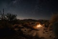 nighttime desert hike with stars and moon overhead, and distant point of light that could be a campfire