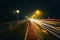 Nighttime long exposure image of a bridge illuminated by the bright lights