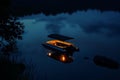 nighttime shot of litup pontoon boat floating on a tranquil lake Royalty Free Stock Photo