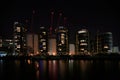 Nighttime view over River Thames to residential apartments and new building construction and cranes with red lights