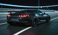 Nighttime view of sports car on city highway, seen from behind, with urban landscape and city lights in background. Dynamic and Royalty Free Stock Photo