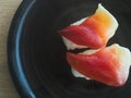 Nigiri hokkigai on black plate japanese food