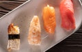 Nigiri sushi with salmon, eel, tuna and prawn, served on white plate. Delicious traditional Japanese food, tasty seafood Royalty Free Stock Photo