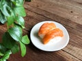 Nigiri Sushi in white dish on the wooden table and green leave foreground Royalty Free Stock Photo