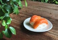 Nigiri Sushi in white dish on the wooden table and green leave foreground Royalty Free Stock Photo