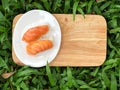 Nigiri Sushi in white dish on the wooden tray any green yard background natural  light. Royalty Free Stock Photo