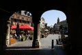 View beyond stone arches on square grote markt with medieval buildings and restaurants in summer