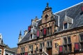 View on medieval ancient building waag house with typical dutch gable roof and red window shutters against blue sky in summer Royalty Free Stock Photo