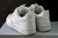Nike Air Force 1 white sneakers isolated on dark background. Illustrative editorial photo.