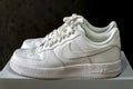 Nike Air Force 1 white sneakers isolated on dark background. Illustrative editorial photo.