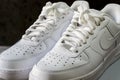 Nike Air Force 1 white sneakers isolated on dark background. Illustrative editorial photo.