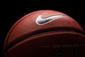 Nike brand, basketball ball Nike Baller. Orange rubber outdoor ball, ultra-durable cover, close-up on a black background