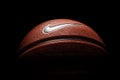 Nike brand, basketball ball Nike Baller. Orange rubber outdoor ball, ultra-durable cover, close-up on a black background