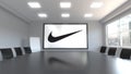 Nike inscription and logo on the screen in a meeting room. Editorial 3D rendering