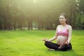 Asian Eastern Chinese young pretty pregnant girl woman do yoga sit in meditation, do lotus gesture of yoga over sunset,namaste Royalty Free Stock Photo