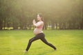 Asian Eastern Chinese young pretty pregnant girl woman do yoga stand in meditation, do lotus gesture of yoga outdoor nature sunset Royalty Free Stock Photo