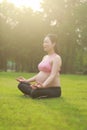 Asian Eastern Chinese young pretty pregnant girl woman do yoga sit in meditation, do lotus gesture of yoga over sunset,namaste Royalty Free Stock Photo