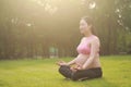 Asian Eastern Chinese young pretty pregnant girl woman do yoga sit in meditation, do lotus gesture of yoga over sunset,namaste Royalty Free Stock Photo