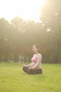 Asian Eastern Chinese young pretty pregnant girl woman do yoga sit in meditation, do lotus gesture of yoga over sunset,namaste Royalty Free Stock Photo