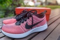 The NIKE pink shoes with red box of women for exercise at the park.