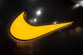 Nike swoosh during glowing with orange lighting color on the black tile.