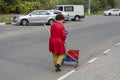 Nikolaev, Ukraine - October 24, 2020: an adult female janitor cleans fallen leaves in parking lot
