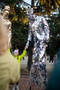 NIKOPOL, UKRAINE - 09/28/2021: Close-up of stilt walkers at the fair. Male acrobats dressed in shiny mirrored costumes. The