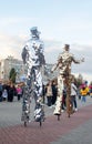 NIKOPOL, UKRAINE - 09/28/2021: Close-up of stilt walkers at the fair. Male acrobats dressed in shiny mirrored costumes. The