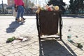 Nikopol, Ukraine, May 20, 2019: a crowded trash can on the Ukrainian street, with garbage on paving slabs Royalty Free Stock Photo