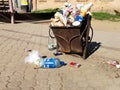 Nikopol, Ukraine, May 20, 2019: a crowded trash can on the Ukrainian street, with garbage on paving slabs Royalty Free Stock Photo