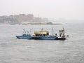 A ferry transporting trucks, cars and people over the Nile.