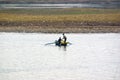 Nile River, near Aswnm, Egypt, February 21, 2017: Two fishermen fishing in a small boat on the Nile River, one of them standing by Royalty Free Stock Photo