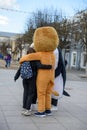 Nimators in costumes from the cartoon Madagascar are photographed with children in the city