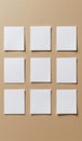 Nine blank white paper sheets arranged in a grid on a beige background, highlighting minimalism and simplicity. Royalty Free Stock Photo