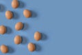 Nine brown eggs on a blue background. The concept of minimalism to your design