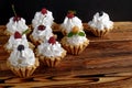 Nine cakes with protein cream and summer berries on wooden table. Black background, selective focus. Royalty Free Stock Photo