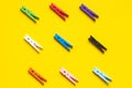 Nine colored clothespins on a yellow background