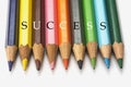 Nine colored pencils with the word success