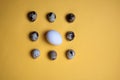 Nine eggs - of quail and a goose isolated on yellow background flat lay